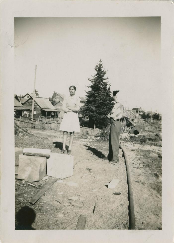 [Two girls standing on dirt path]