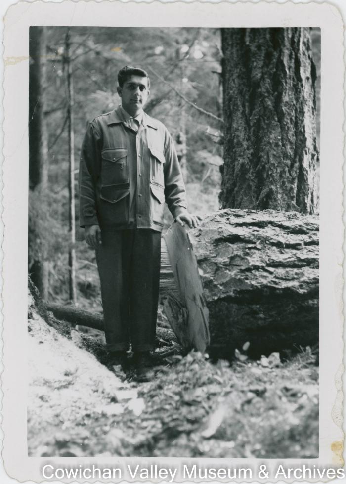 Reg Rajindi Mayo standing beside felled log