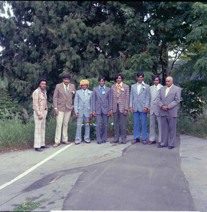 [Photo of Baldave Sidhu and seven unidentified men]