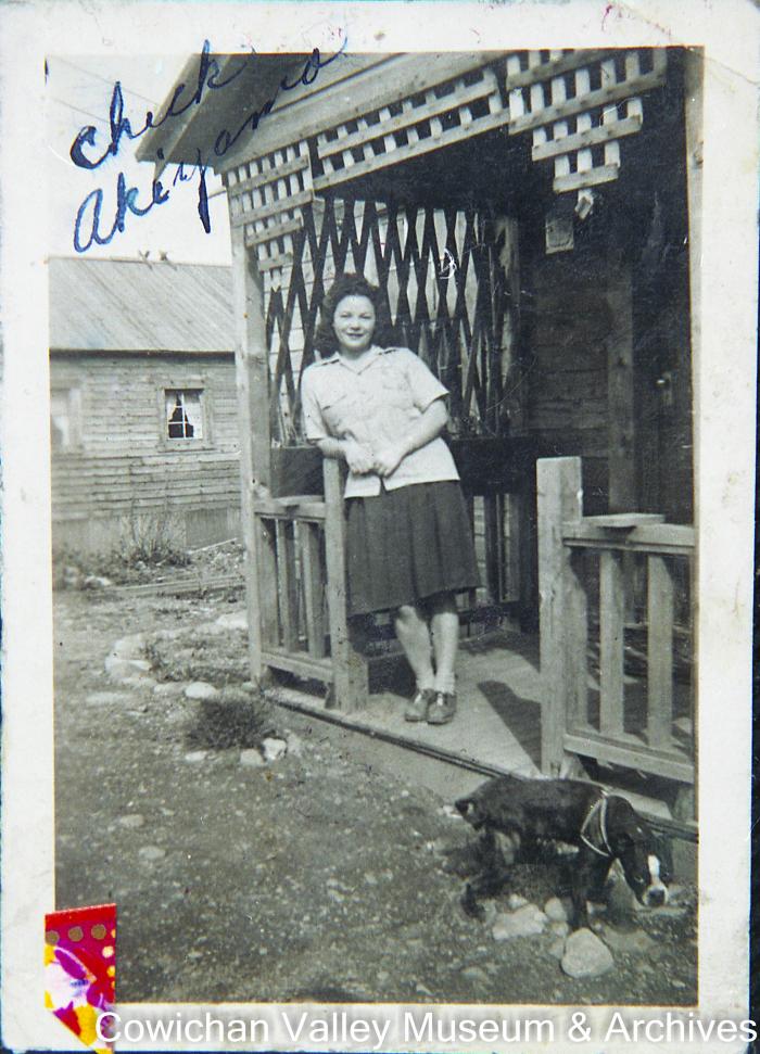 Chic Akiyma in front of Johnny and Mary Lowe's house on south side of village