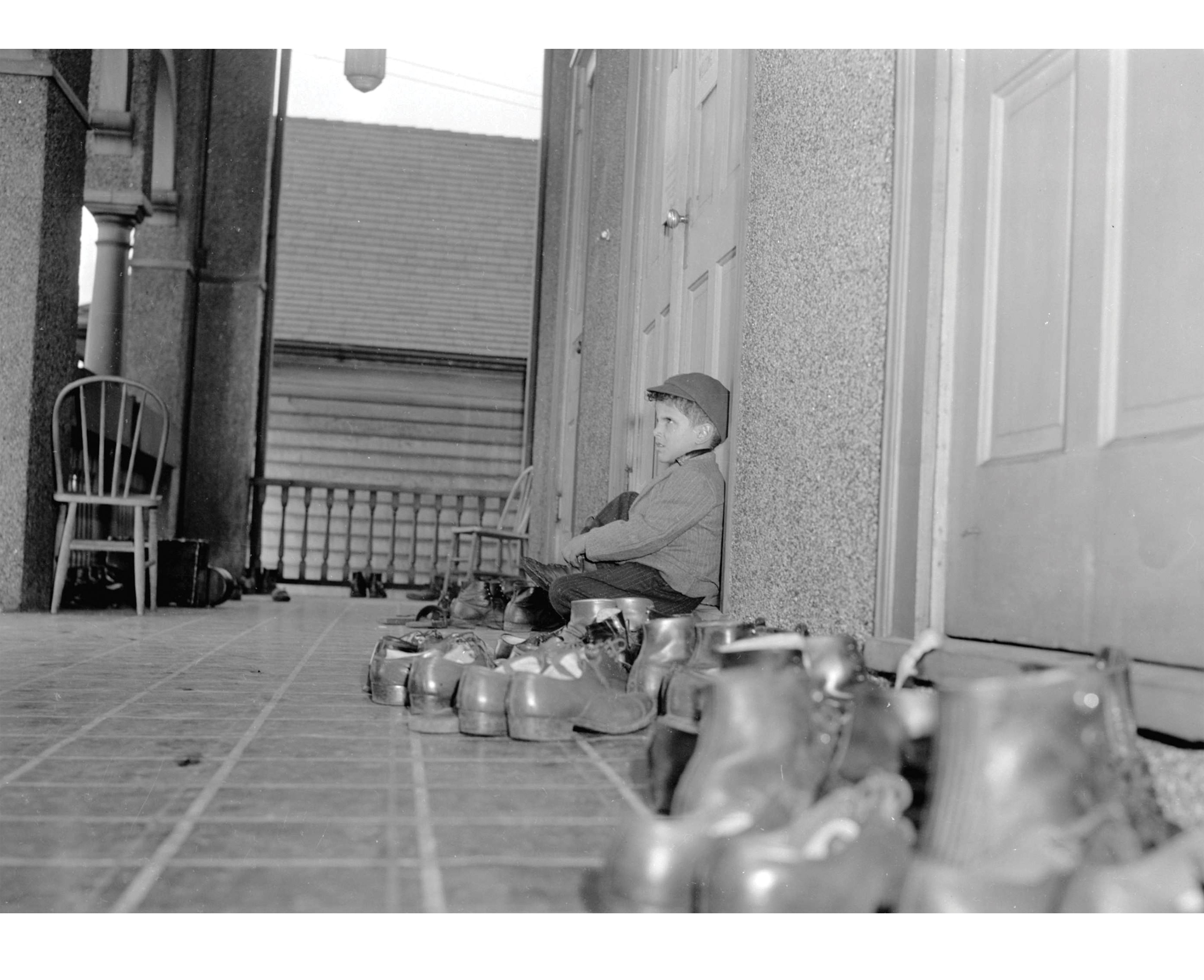 Boy taking off shoes outside the Khalsa Diwan Society Sikh Temple, March 1945