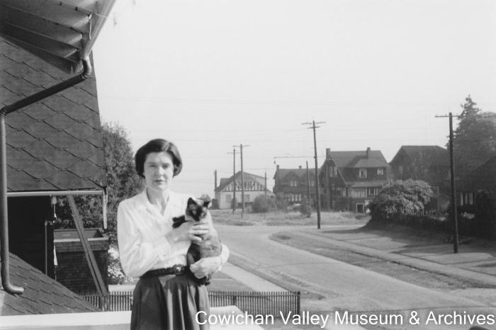 [A woman posing for a photo while holding a cat]
