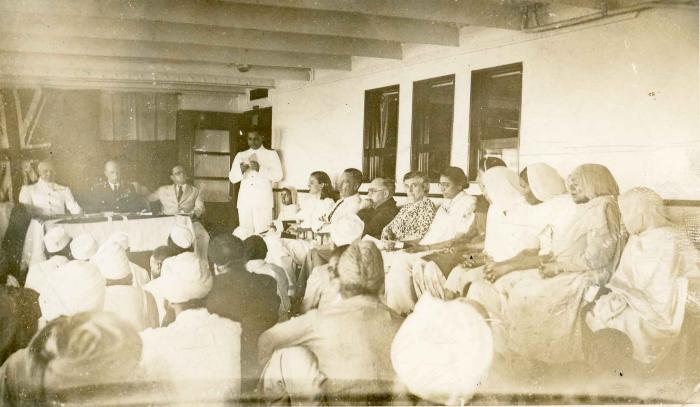 [Photo of a seated group being addressed by navy official]