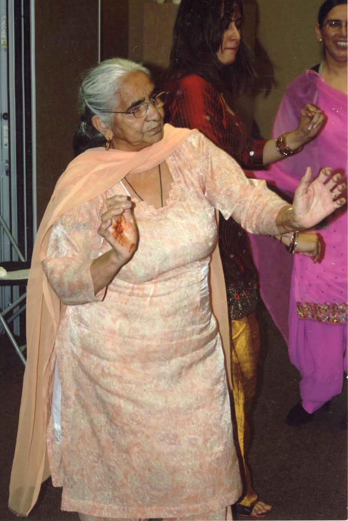 [Photo of Surjit Kaur dancing at a wedding]