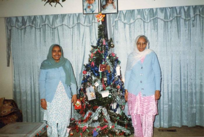 [Photo of Surjit Kaur with a Christmas tree]