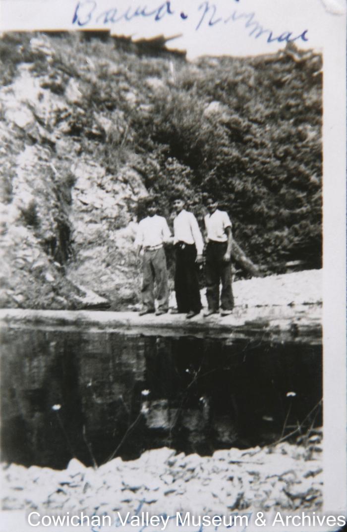 [Three young men posing for a photo next to a lake]