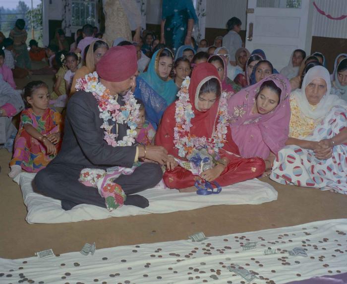 [Photo of an unidentified groom with an unidentified bride]