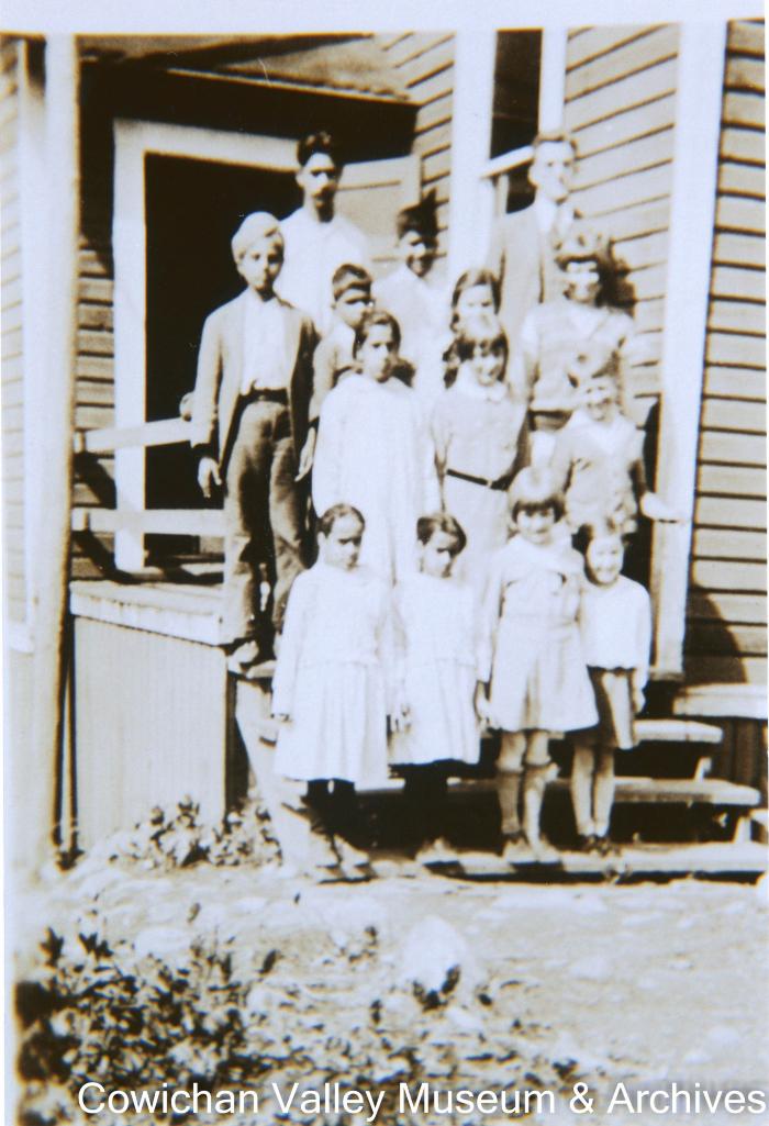 [Students and their teacher posing in front of a building]