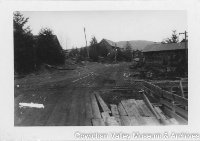 [Image of a dirt road with buildings on either side]