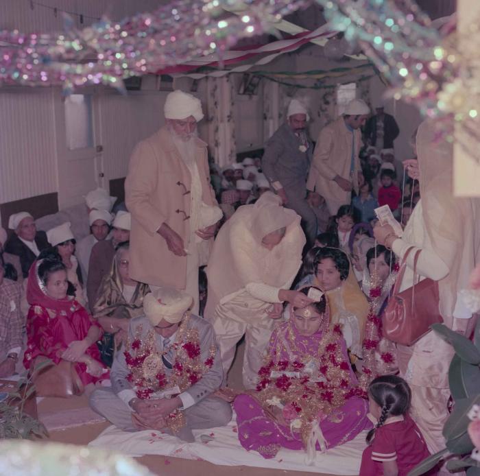 [Group photo of Vern Thind and Rupinder Mann with wedding guests]
