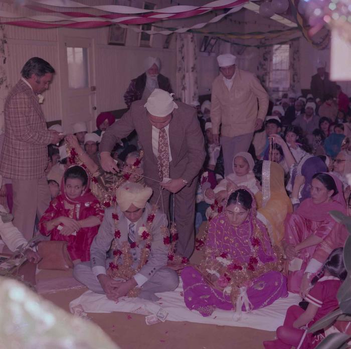 [Group photo of Vern Thind and Rupinder Mann with wedding guests]