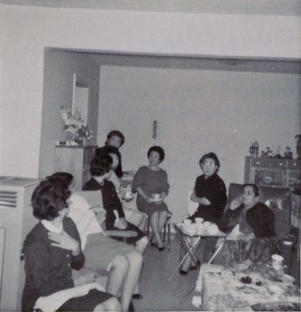 [Photo of a group of women sitting inside a house]