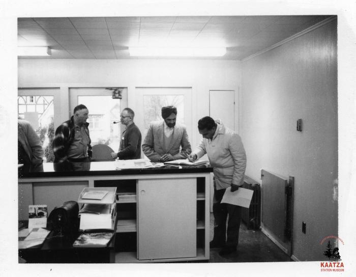 [Photo of IWA members signing papers in an office, including IWA Local 1-80 Balloting Chairman Jager Gill]