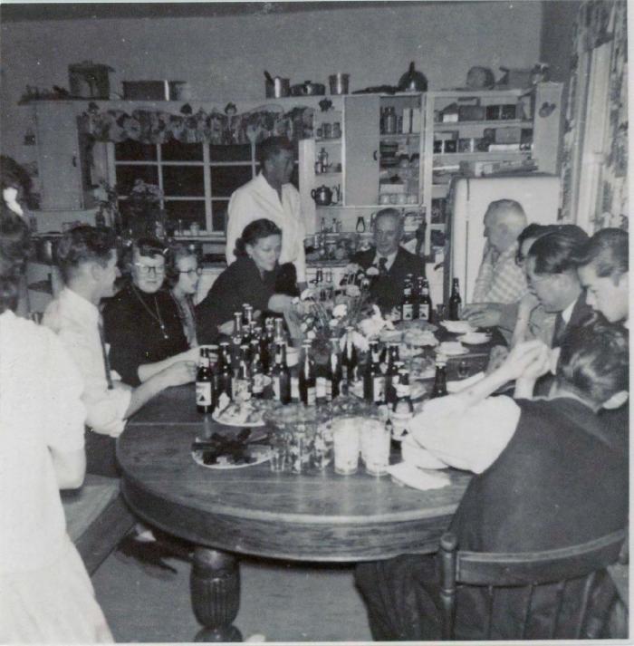 [Photo of a group of men and women sitting at a dining table]