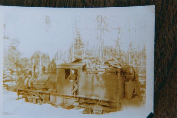 [Photo of an unidentified man standing on the steam locomotive]