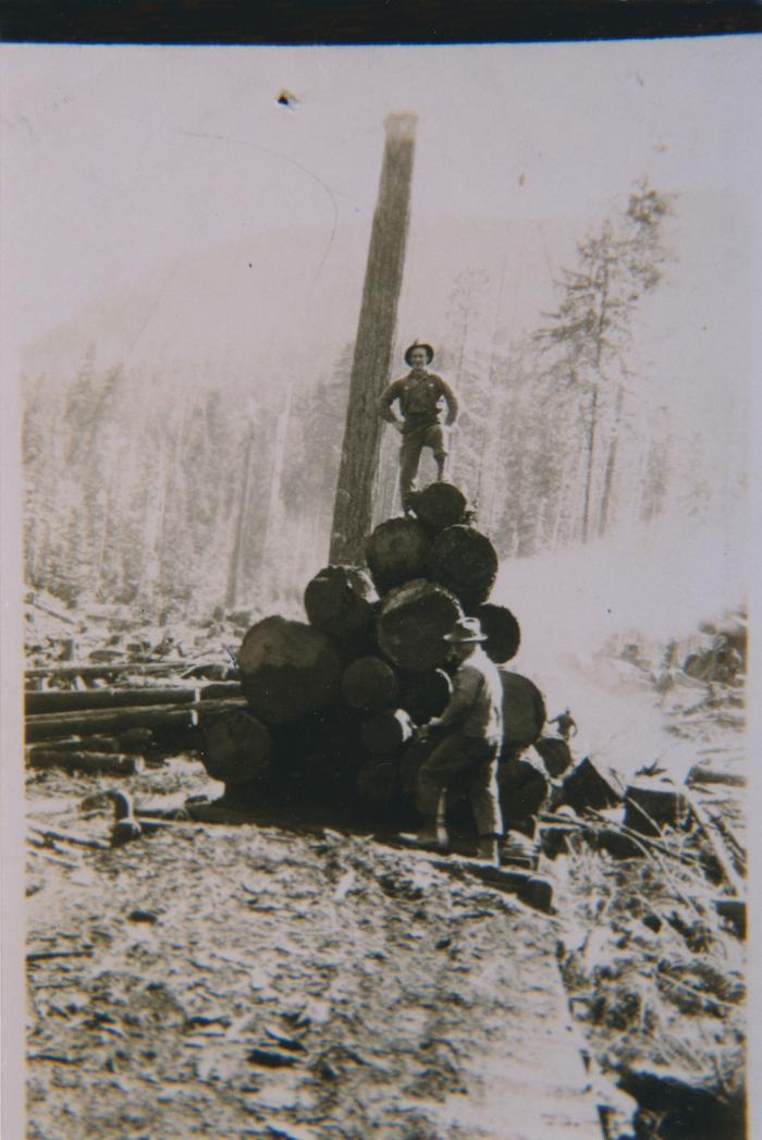 [Photo of an unidentified man standing on a stack of logs in Duncan, B.C.]