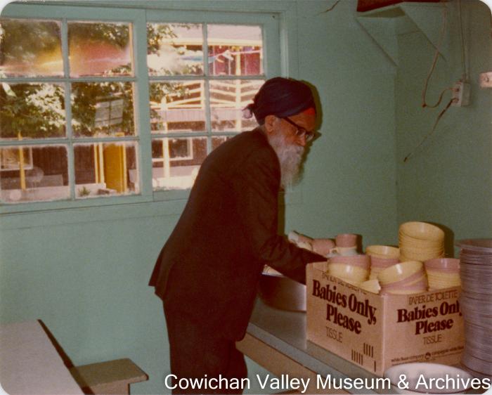 Image of an unidentified man putting dishes away