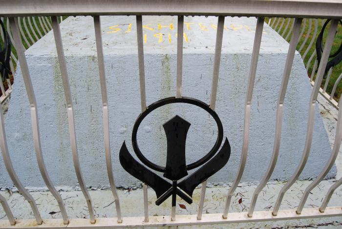 [Photo of the Sikh symbol, the khanda on fence]