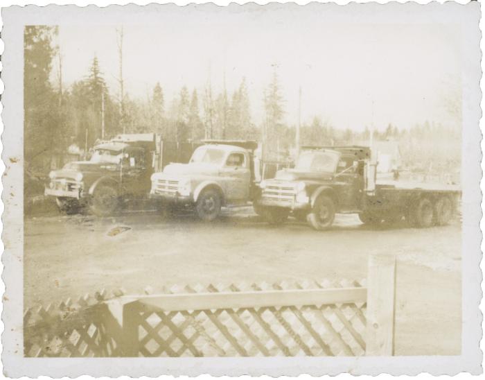 [Photo of three hauling trucks by the side of a rural roadway]