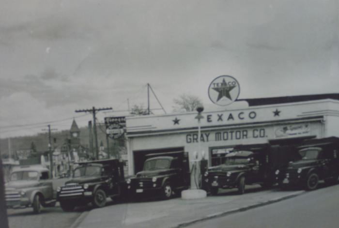 [Photo of five hauling trucks parked outside a fuelling station]