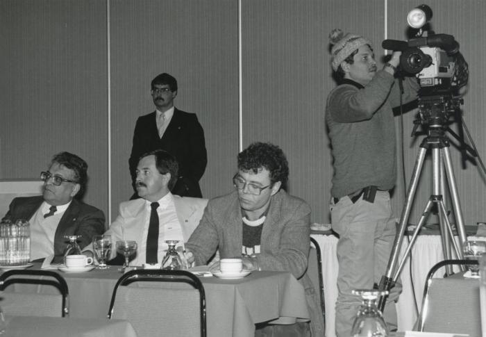 [Group photo of Herb Doman, three other businessmen, and a cameraman at an unidentified company function]