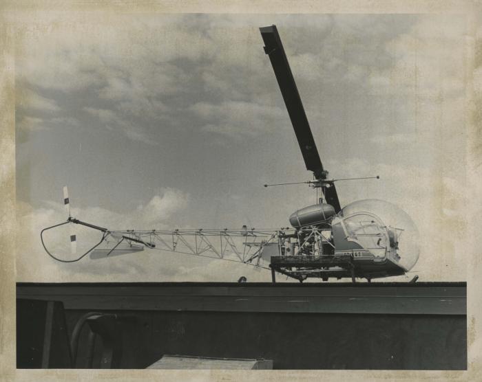 [Photo of a bell 47 helicopter on a helipad]