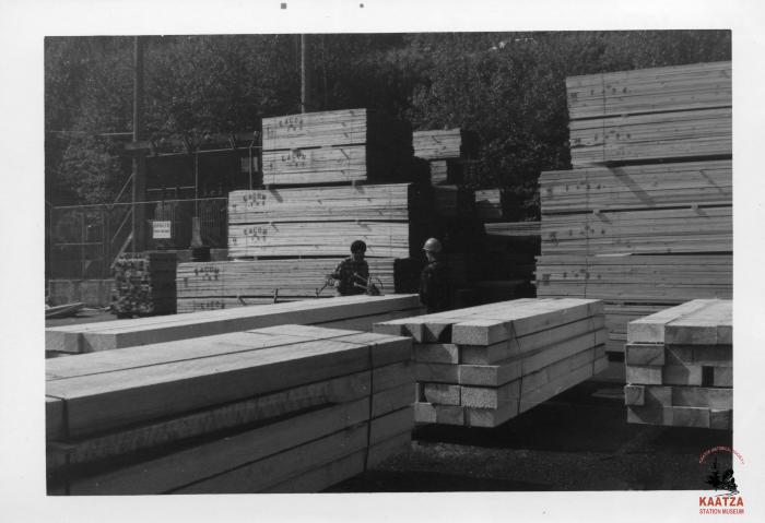 [Photo of lumber workers banding timbers at Mayo Lumber in Nanaimo, B.C.]