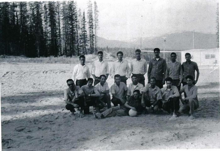 [Group photo of Rajinder Singh Gill with unidentified South Asian men on a volleyball court]
