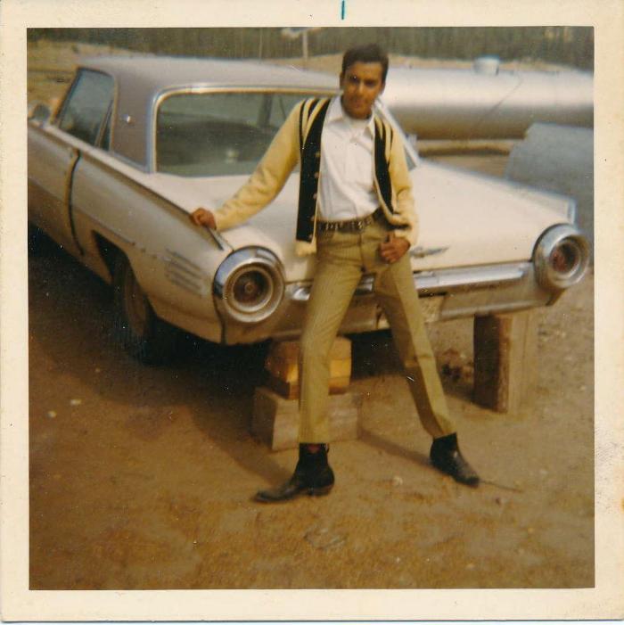 [Photo of Rajinder Singh Gill posing in front of a car]