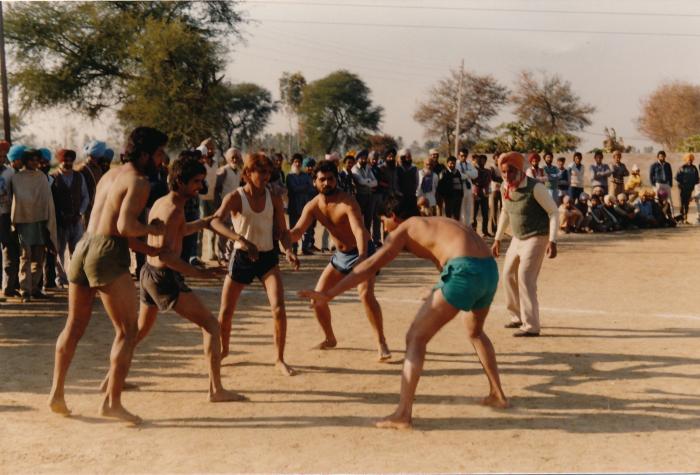 [Group photo of Sukhwinder Bolla playing kabbadi with other unidentified men]