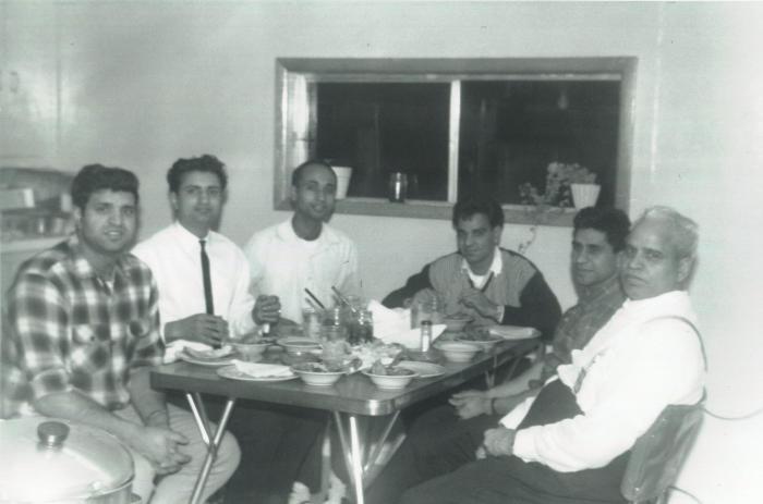 [Group photo of Sukhdev Singh Dhaliwal eating with five other men]