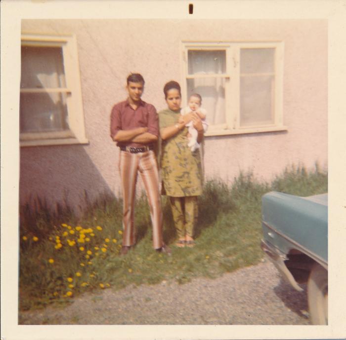 [Photo of Rajinder Singh Gill standing with an unidentified woman and child]