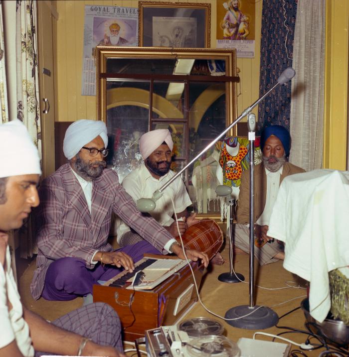 [Photo of three unidentified musicians and one unidentified sound engineer]