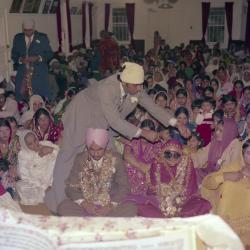 [Photo of Surinder Gill, G.K. Sidhu and their wedding guests on the steps of the Gurdwara]