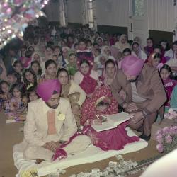 [Photo of wedding guests in the Gurdwara facing the Granthi]