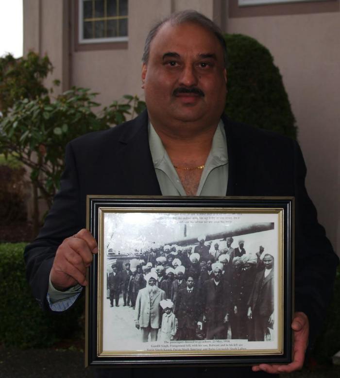 [Jaswinder Singh Toor holding photograph of Komagata Maru passengers, including his grandfather, Puran Singh Johal]