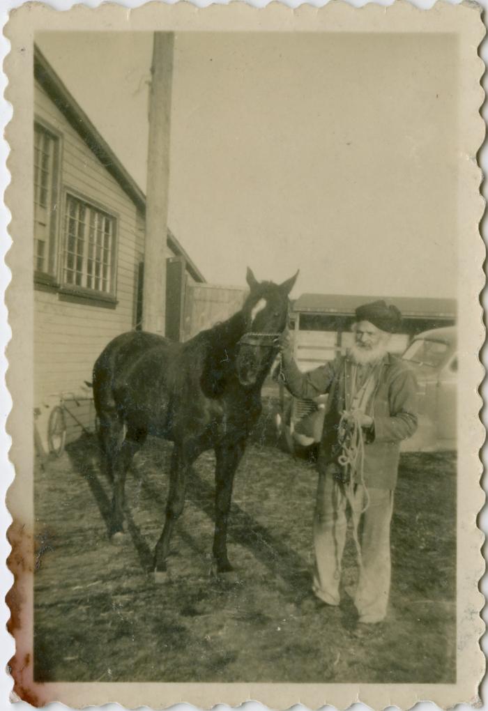 [Photo of Thakar Singh with one of his race horses outside a barn at the Brighouse Racetrack in Richmond, BC, circa 1940’s]