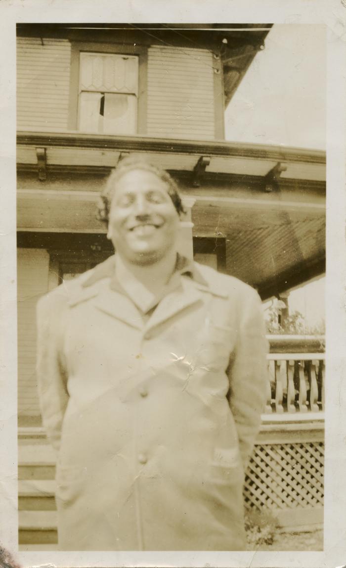 [Photo of Phangan Singh Gill in front of Gurdas Singh and Bhani Kaur's family home in Queensborough]