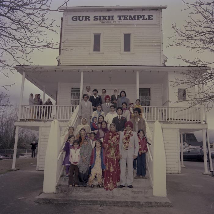 [Group photo of Inderjeet Guran, Basant Brar and wedding guests on the Gurdwara steps]