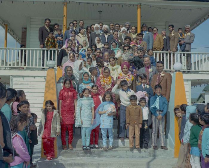 [Group photo of H.S. Dhaliwal, an unidentified bride and wedding guests on the Gurdwara steps]