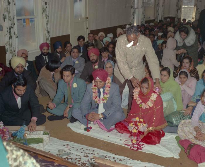 [Photo of Daljit Dhaliwal, an unidentified bride and wedding guests]
