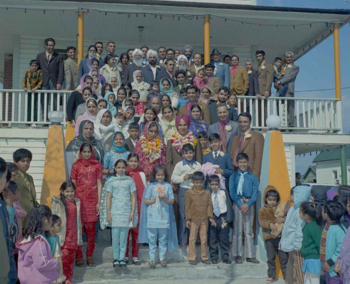 [Group photo of H.S. Dhaliwal, an unidentified bride and wedding guests on the Gurdwara steps]