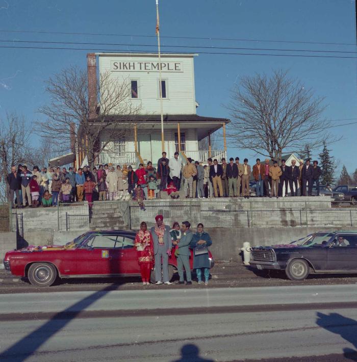 [Photo of Daljit Dhaliwal, an unidentified bride and wedding guests outside of the Gurdwara]
