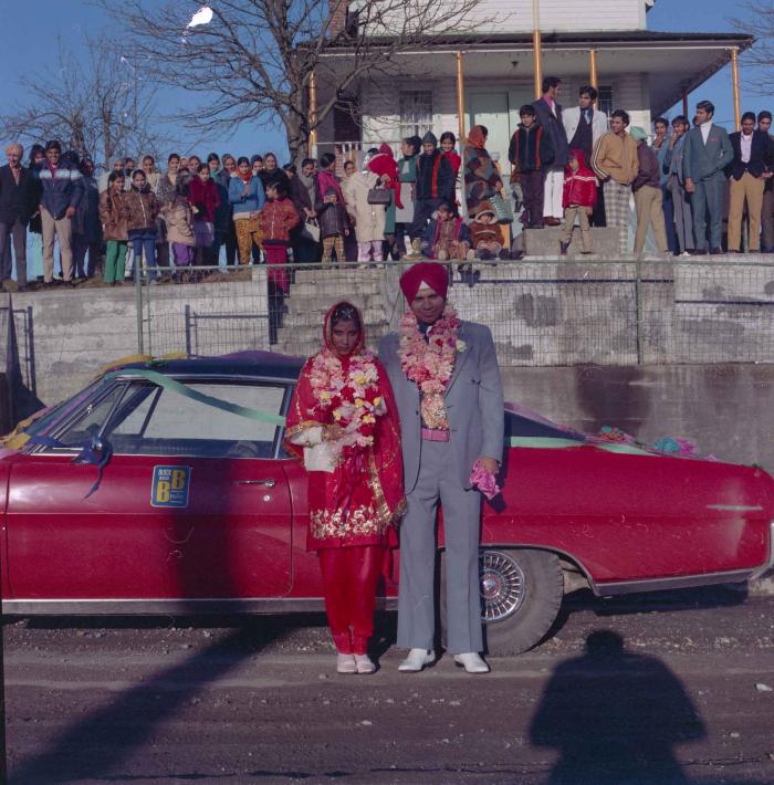 [Photo of Daljit Dhaliwal, an unidentified bride and wedding guests outside of the Gurdwara]