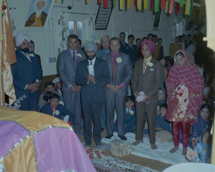 [Photo of H.S. Dhaliwal, an unidentified bride and wedding guests]