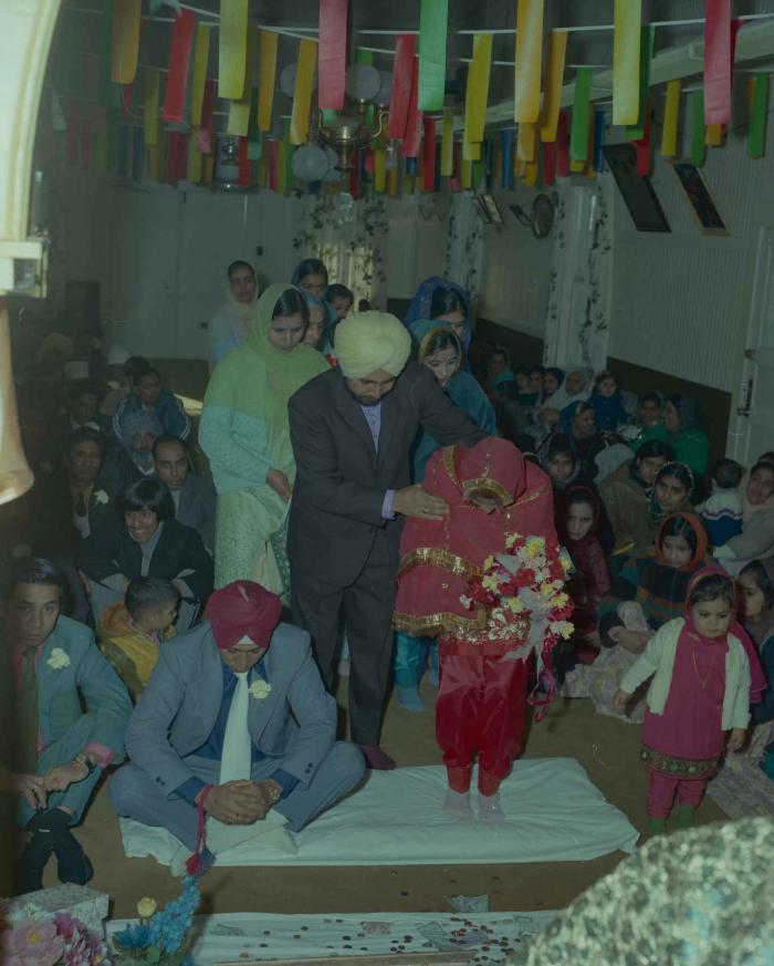 [Photo of Daljit Dhaliwal, an unidentified bride and wedding guests]