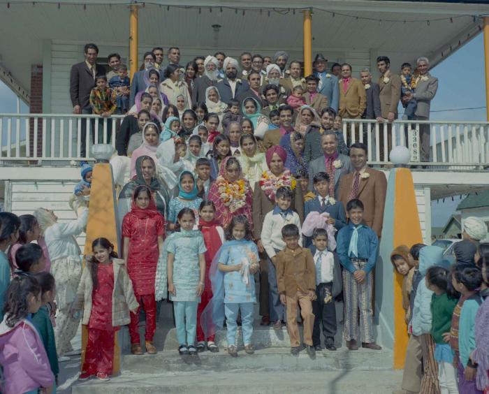 [Group photo of H.S. Dhaliwal, an unidentified bride and wedding guests on the Gurdwara steps]