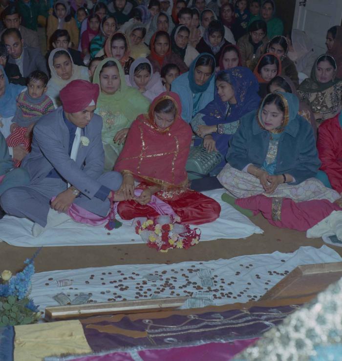 [Photo of Daljit Dhaliwal, an unidentified bride and wedding guests]