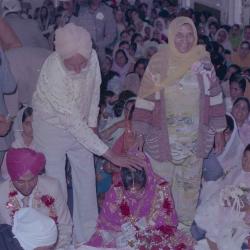 [Photo of Ajmer S. Sidhu, an unidentified woman and wedding guests on the Gurdwara steps]