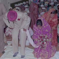 [Photo of Narwal Sidhu, an unidentified woman and their wedding guests]